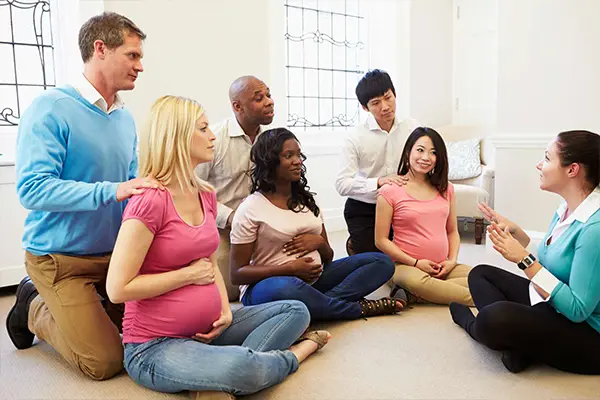 Paar nimmt gemeinsam an einem Wochenend-Geburtsvorbereitungskurs teil, um sich auf die bevorstehende Geburt vorzubereiten.